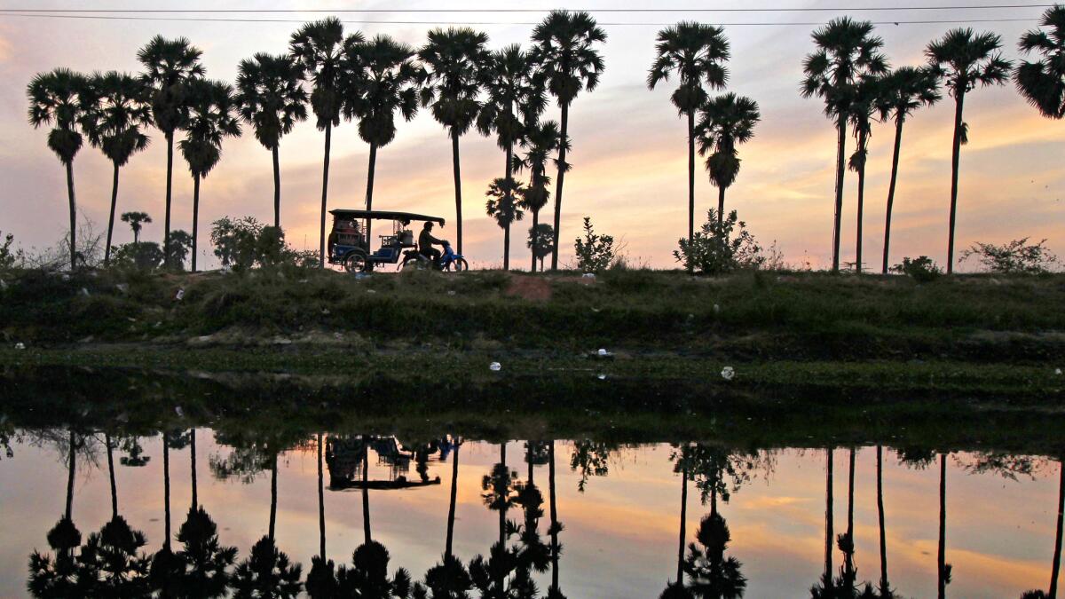 A man drives a motor cart at dawn as he takes passengers into town from the outskirts of Phnom Penh, Cambodia. Motorcycle-based transportation continues to be popular in the developing nation, which can be reached for less than $800 on Eva Air.