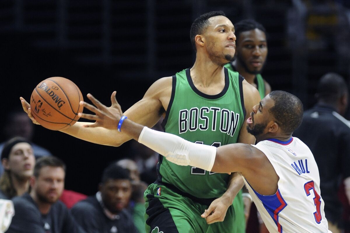 Chris Paul tries to swipe the ball away from Celtics guard Evan Turner during the Clippers' 102-93 win over Boston at Staples Center.