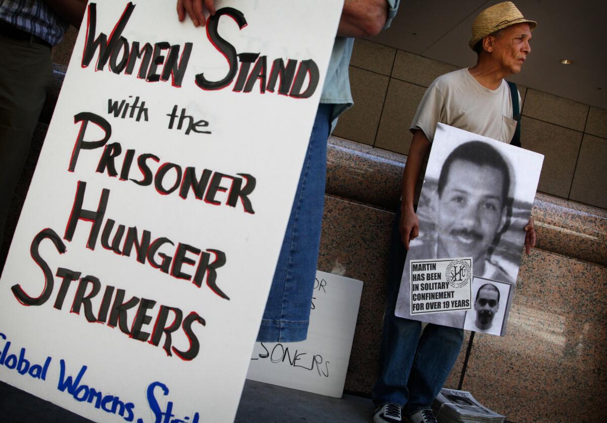 John A. Imani, right, joins about 75 demonstrators Monday in front of the Ronald Reagan State Building in Los Angeles for a rally held in support of Pelican Bay State Prison inmates who are refusing meals in protest of conditions at the prison.