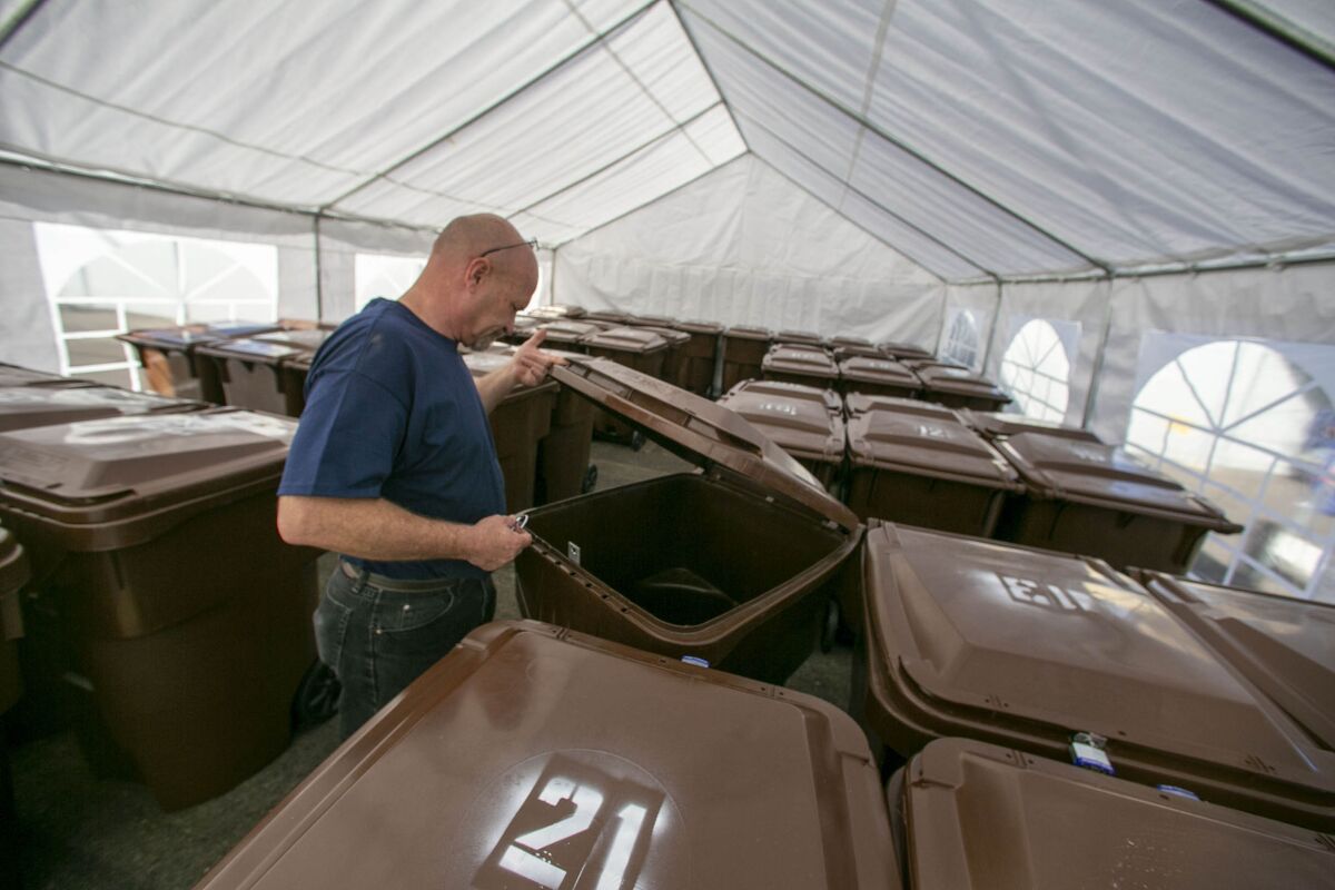 Earl Childress, the site supervisor for the city's third Storage Connect Center for homeless people, looks in one of the 50 bins at the El Cerrito facility Monday. The center can hold up to 500 bins if expanded.
