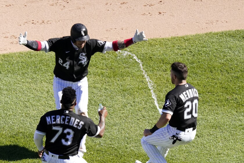 Chicago White Sox's Yasmani Grandal, center, celebrates his game winning single with Yermin Mercedes, left, and Danny Mendick, right, during the 10th inning of a baseball game against the Tampa Bay Rays Wednesday, June 16, 2021, in Chicago. (AP Photo/Charles Rex Arbogast)