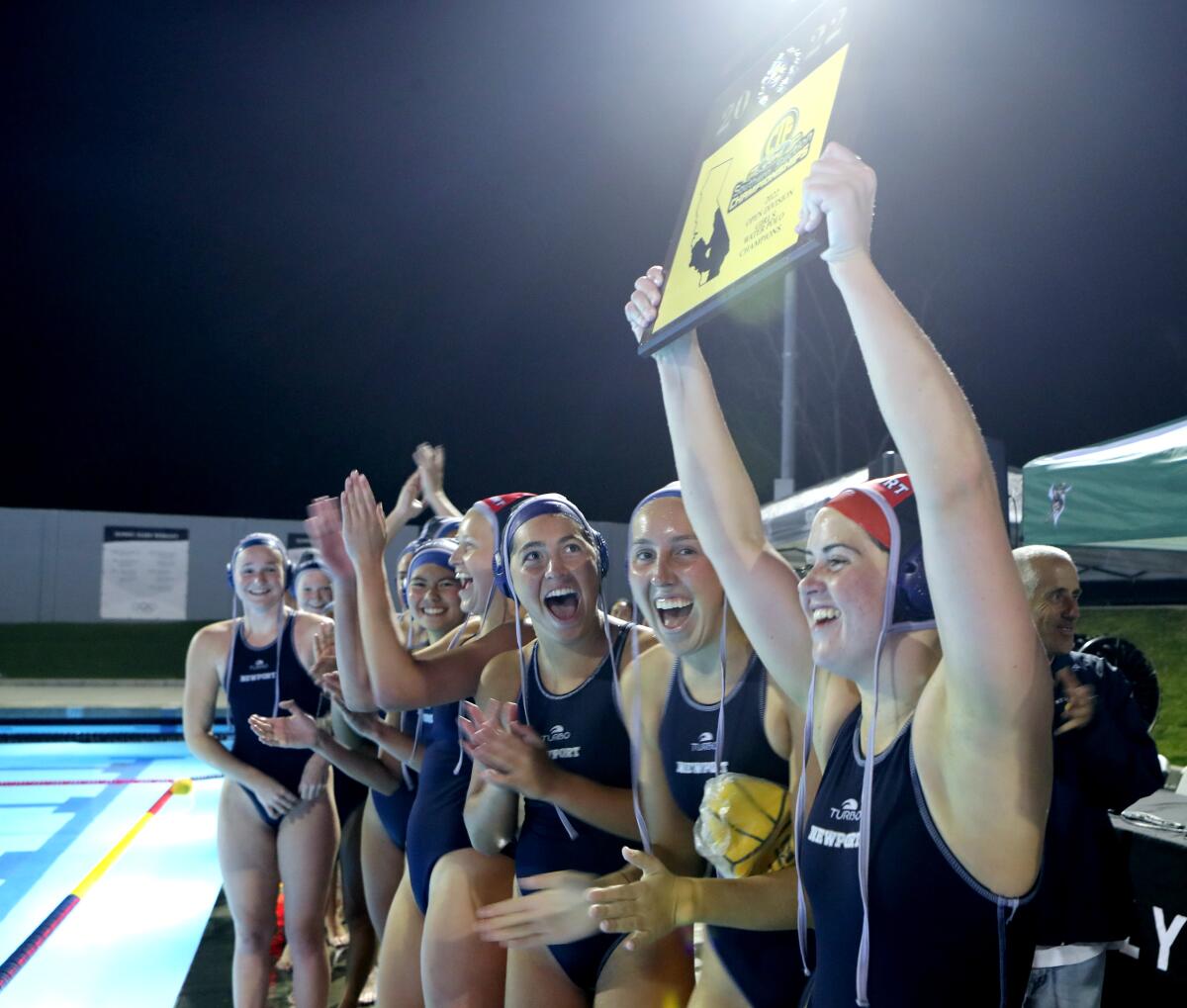 Goalkeeper Anna Reed holds up the title plaque as the Newport Harbor girls' water polo team celebrates Saturday's title.