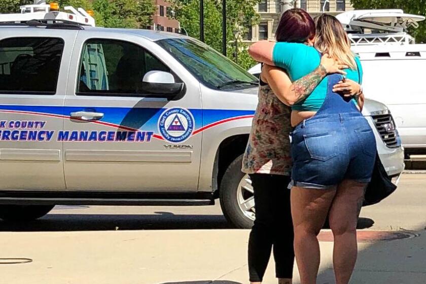 Residents in Dayton, Ohio, comfort each other as they await word on whether they know any of the victims of a mass shooting.