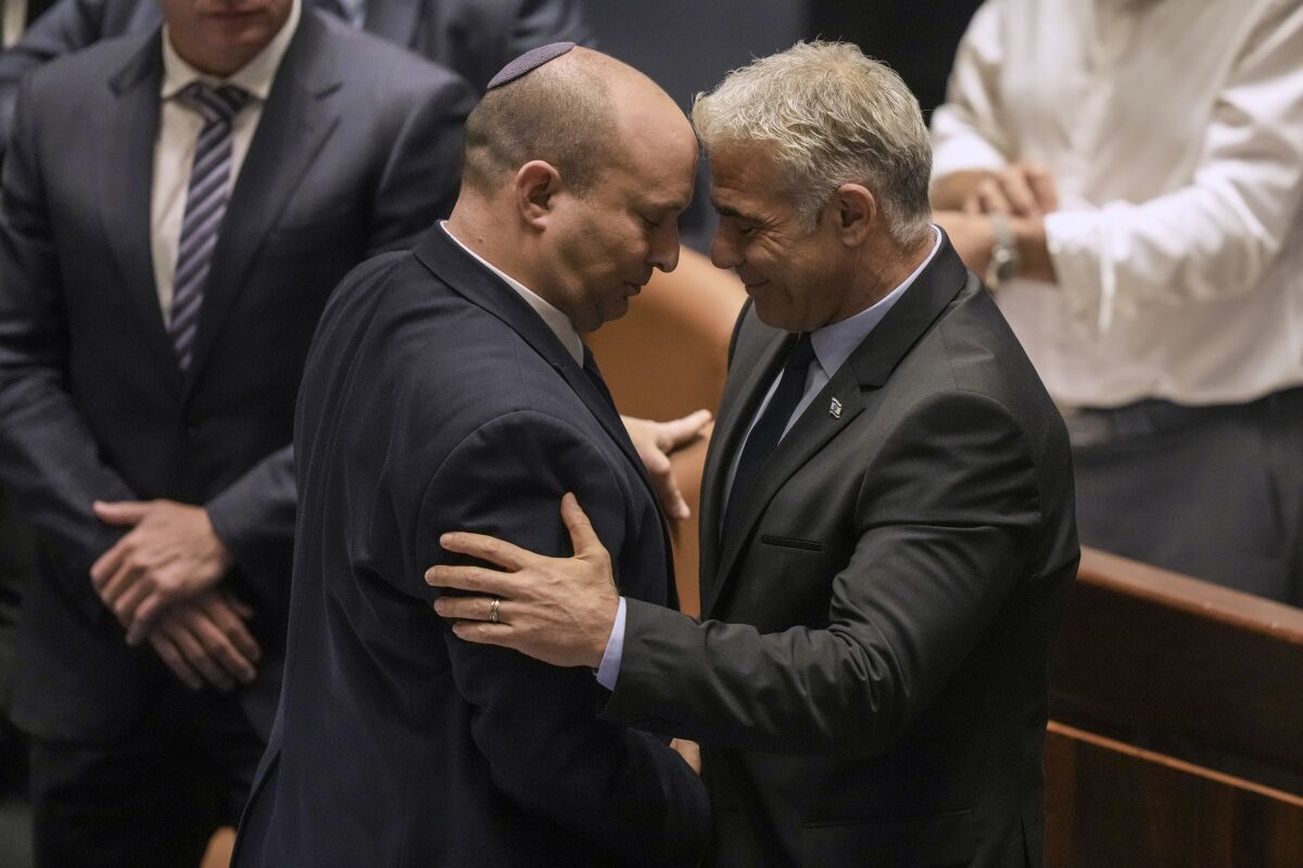 Israeli Prime Minister Naftali Bennett and Foreign Minister Yair Lapid with their heads together