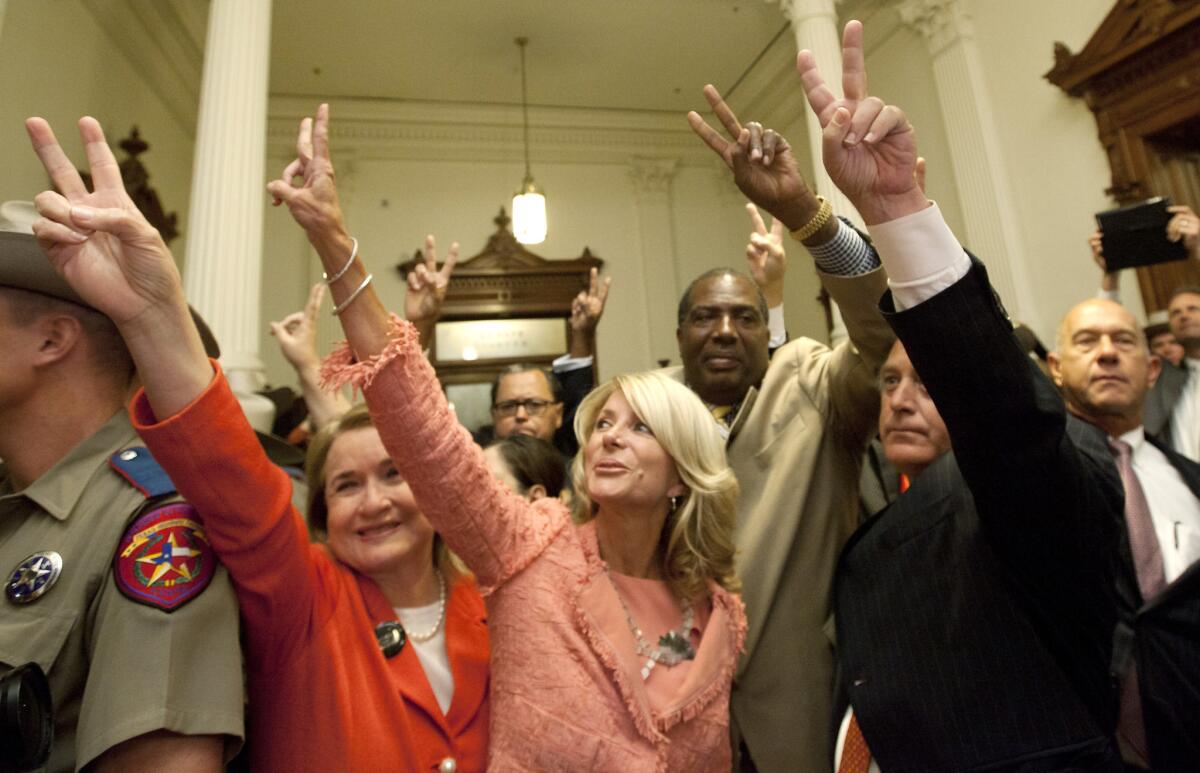 Texas state Sen. Wendy Davis, center, greets a crowd with fellow Democrats indicating their opposition to House Bill 2, which was approved Friday night. The bill sharply curbs abortion rights in the state.