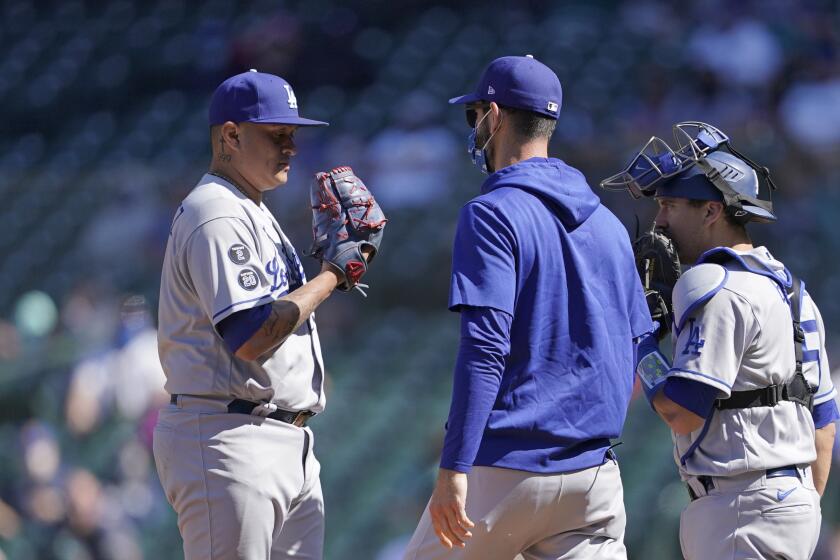 Los Angeles Dodgers relief pitcher Victor Gonzalez, left, is visited by pitching coach Mark Prior.