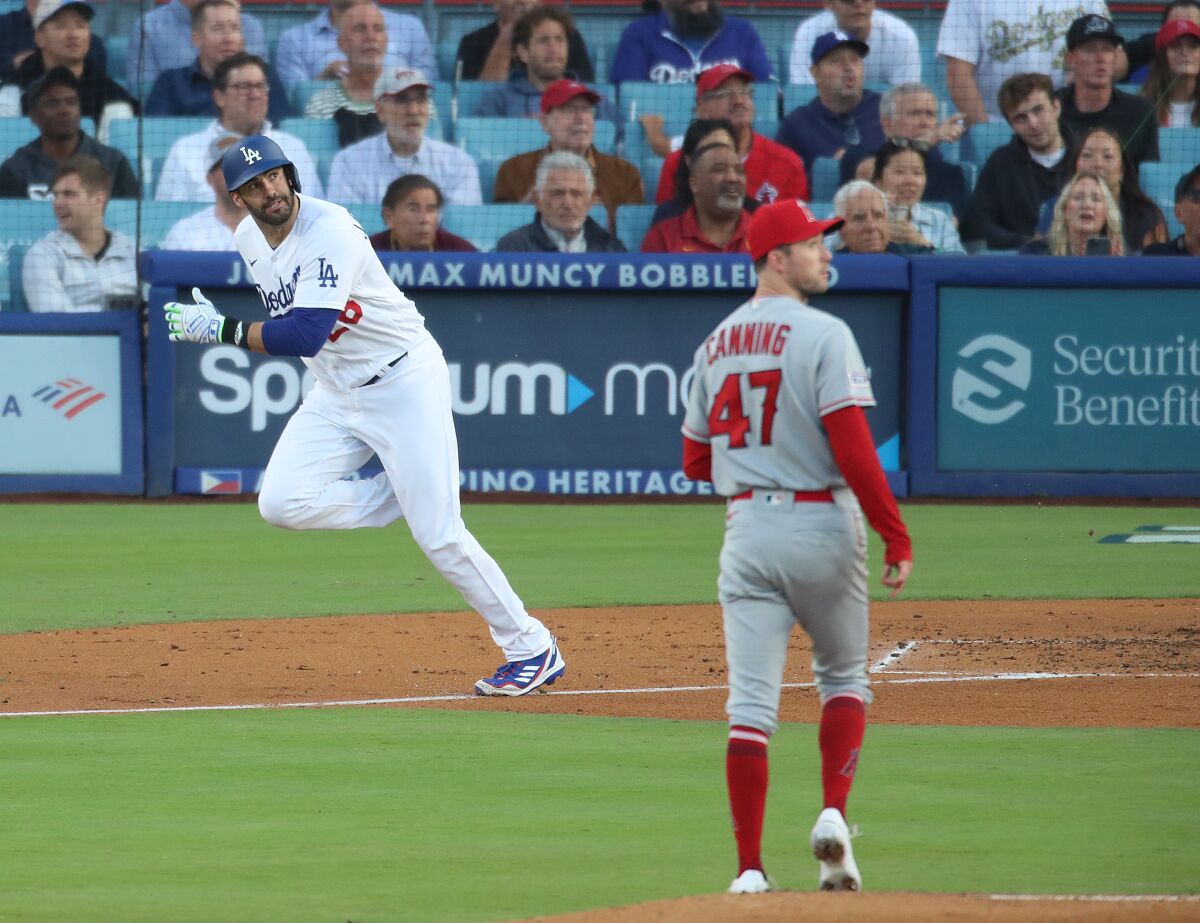 Dodgers designated hitter JD Martinez watches his home run skyrocket as Angels pitcher Griffin Canning looks on