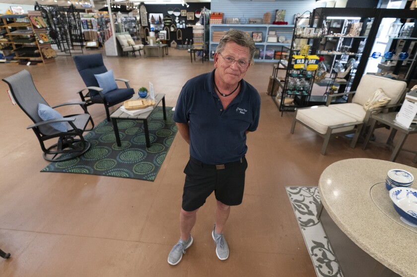 In this July 6, 2021, photo John Hessler, 62, the patio section manager at Valley View Farms in Cockeysville, Md., poses for The Associated Press in his showroom. (AP Photo/Julio Cortez)