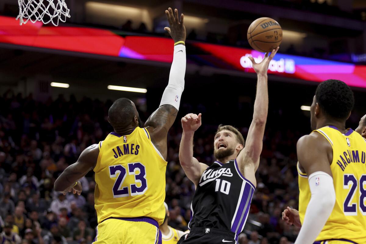 Kings forward Domantas Sabonis shoots against Lakers forward LeBron James 