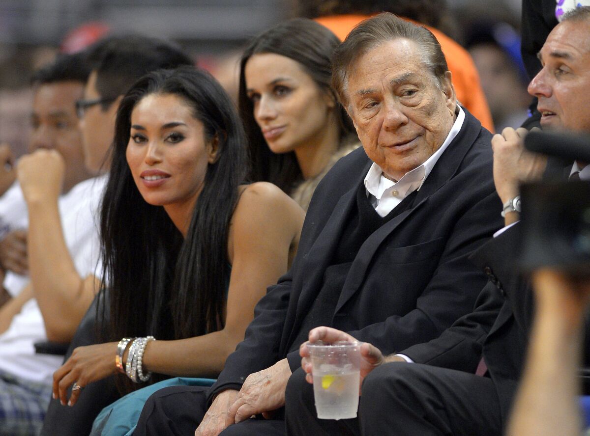 Then-Clippers owner Donald Sterling and V. Stiviano attend a game against the Sacramento Kings in 2013.