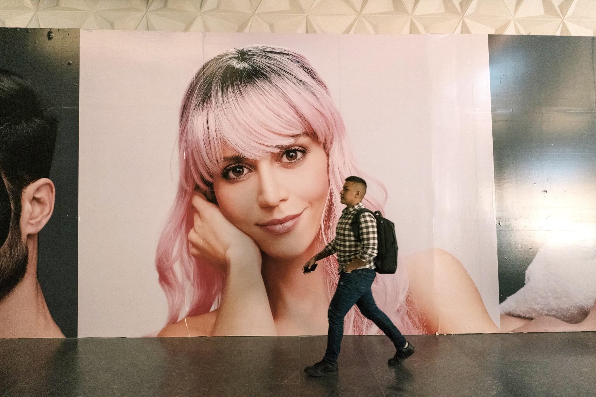 A man walks by a large ad depicting a blond woman 