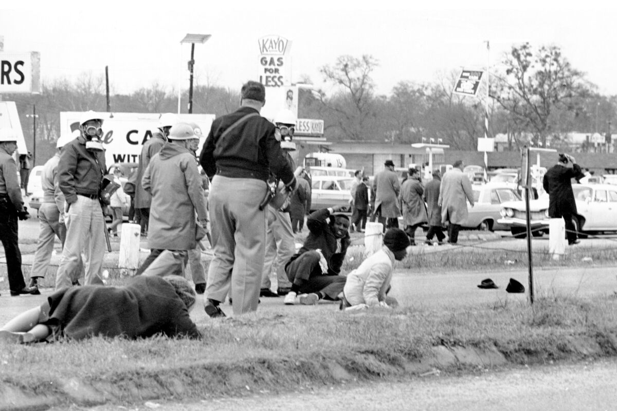 FILE - In this March 7, 1965, file photo, civil rights demonstrators struggle on the ground as state troopers break up a march in Selma, Ala. The world knows the names of John Lewis and a few more of the voting rights demonstrators who walked across Selma's Edmund Pettus Bridge in 1965 only to be attacked by Alabama state troopers on a day that came to be called “Bloody Sunday.” A new project aims to identify more of the hundreds of people who were involved in the protest. (AP Photo/File)