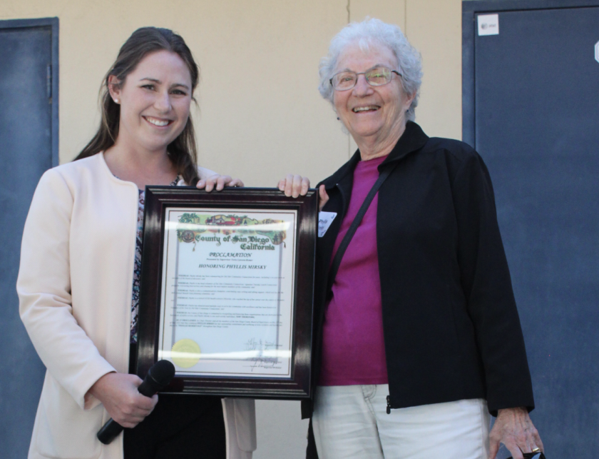 Phyllis Mirsky receives a proclamation from Amanda Berry, representative of Supervisor Terra Lawson-Remer.