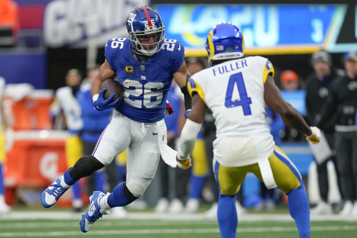 Rams safety Jordan Fuller (4) lines up a tackle of Giants running back Saquon Barkley (26).