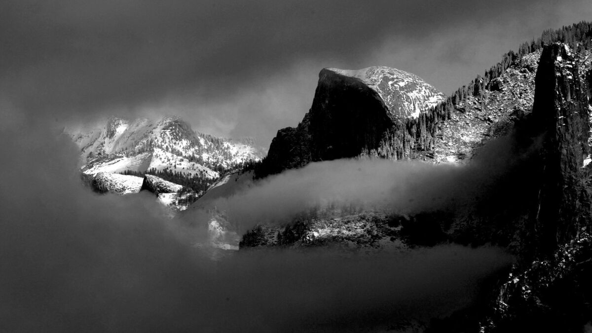 Half Dome peaks out from the clouds.