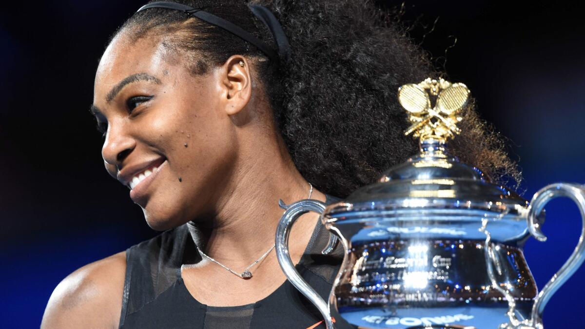 Serena Williams holds up the winner's trophy following her victory over sister Venus Williams in the Australian Open women's singles championship match on Jan. 28, 2017.