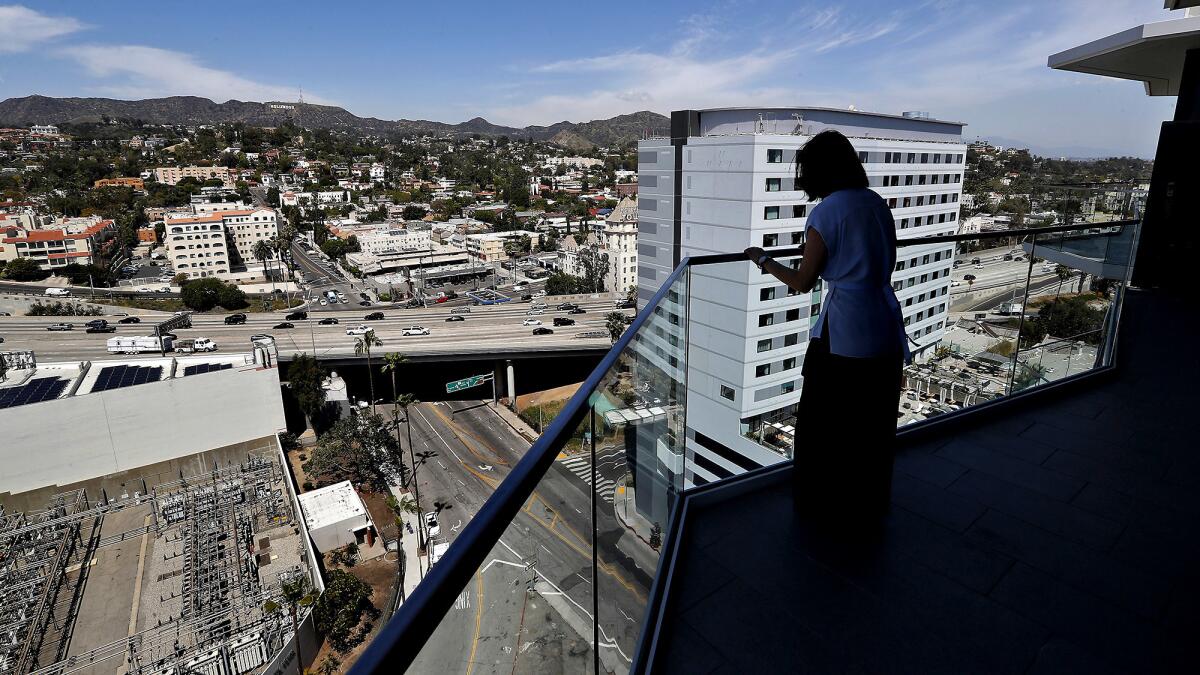 Phoebe Yee, senior vice president for Related, checks out the view from the 18th-floor balcony. For the design, “we’re going for an indoor-outdoor midcentury vibe,” the architect says.