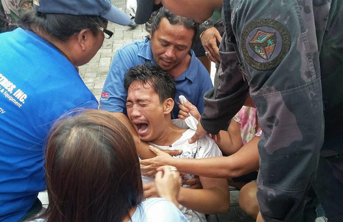 A survivor of a ferry capsizing off the Philippines cries upon arriving at the pier in Ormoc on July 2.