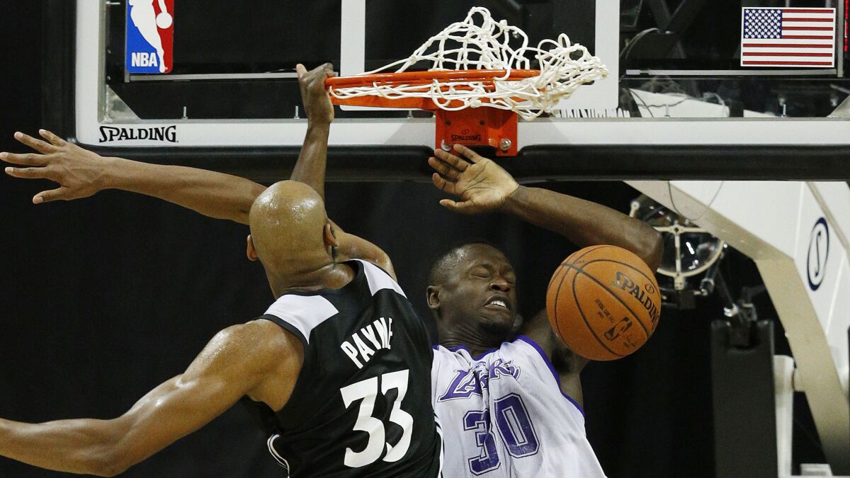 Lakers forward Julius Randle, right, dunks over Minnesota Timberwolves forward Adreian Payne during an NBA summer league game in Las Vegas on July 10.