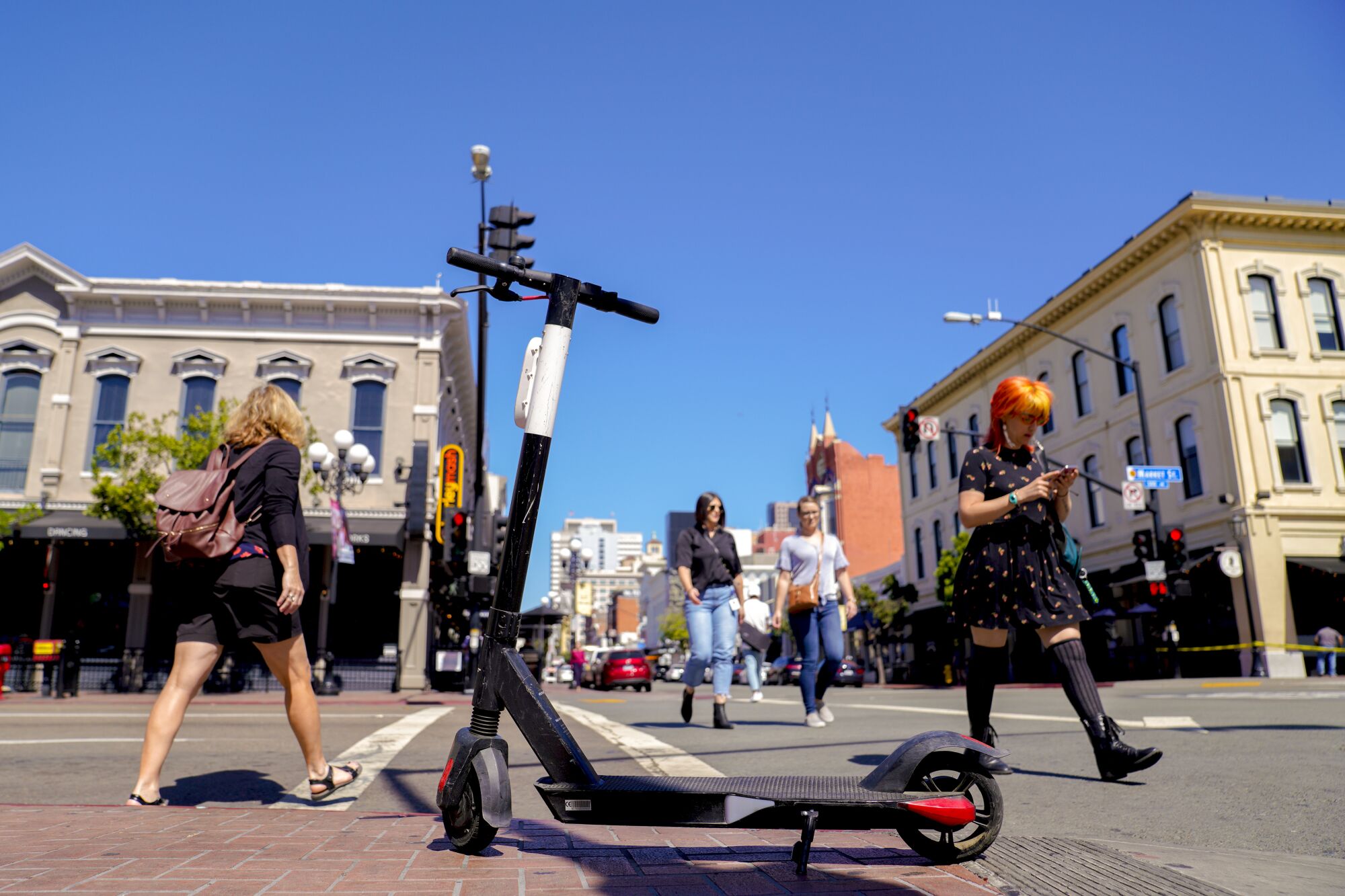 A motorized scooter left on the sidewalk at the corner of Market and Fifth Avenue forced pedestrians to walk around it.