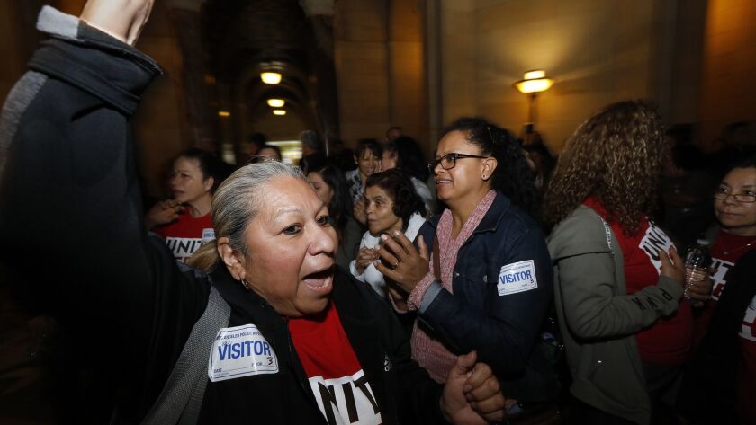 Anna Ledesma, left, a housekeeper with the Westin Bonaventure Hotel in Los Angeles for the last 21 years, cheers with other workers after the City Council unanimously backed a set of proposed rules Wednesday that would allow Angelenos to host rentals only in their own homes.