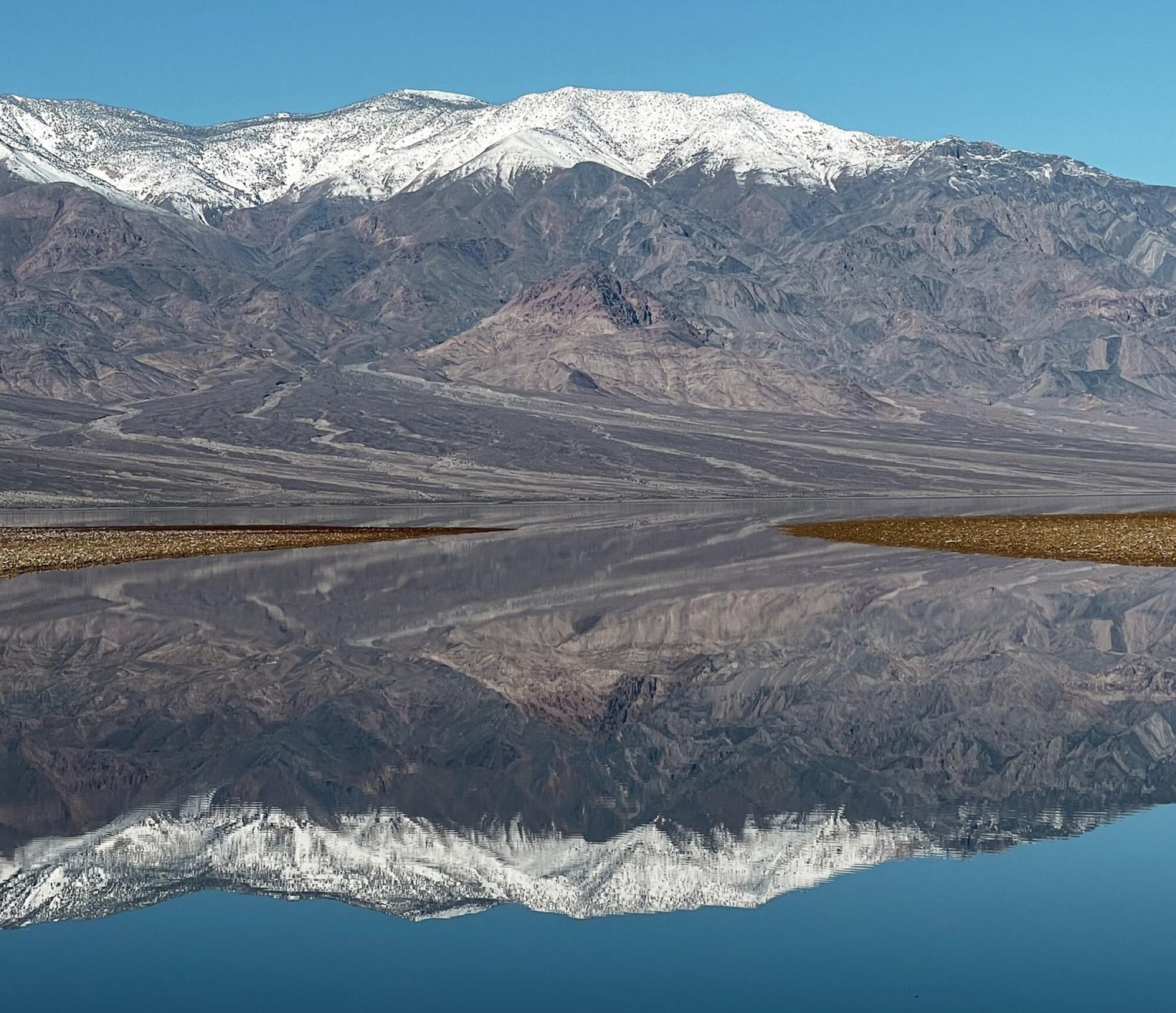 Reflections off a water filled Badwater Basin in Death Valley National Park on Feb. 12, 2024.