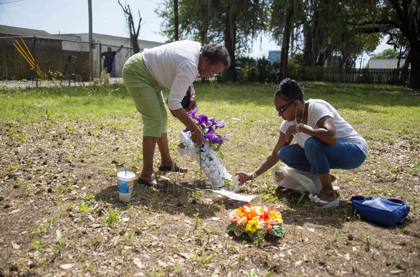 Walter Scott's cousin Barbara Scott, right, leaves flowers at the lot where Scott was fatally shot in North Charleston, S.C. With her is her mother, Evaliana Smalls.