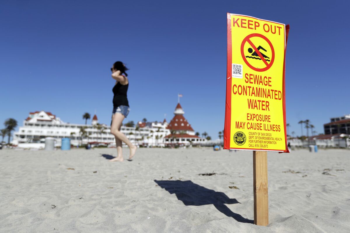 A sign warns of sewage-contaminated ocean waters on a beach in front of the iconic Hotel del Coronado on Wednesday, March 1, 2017, in Coronado.