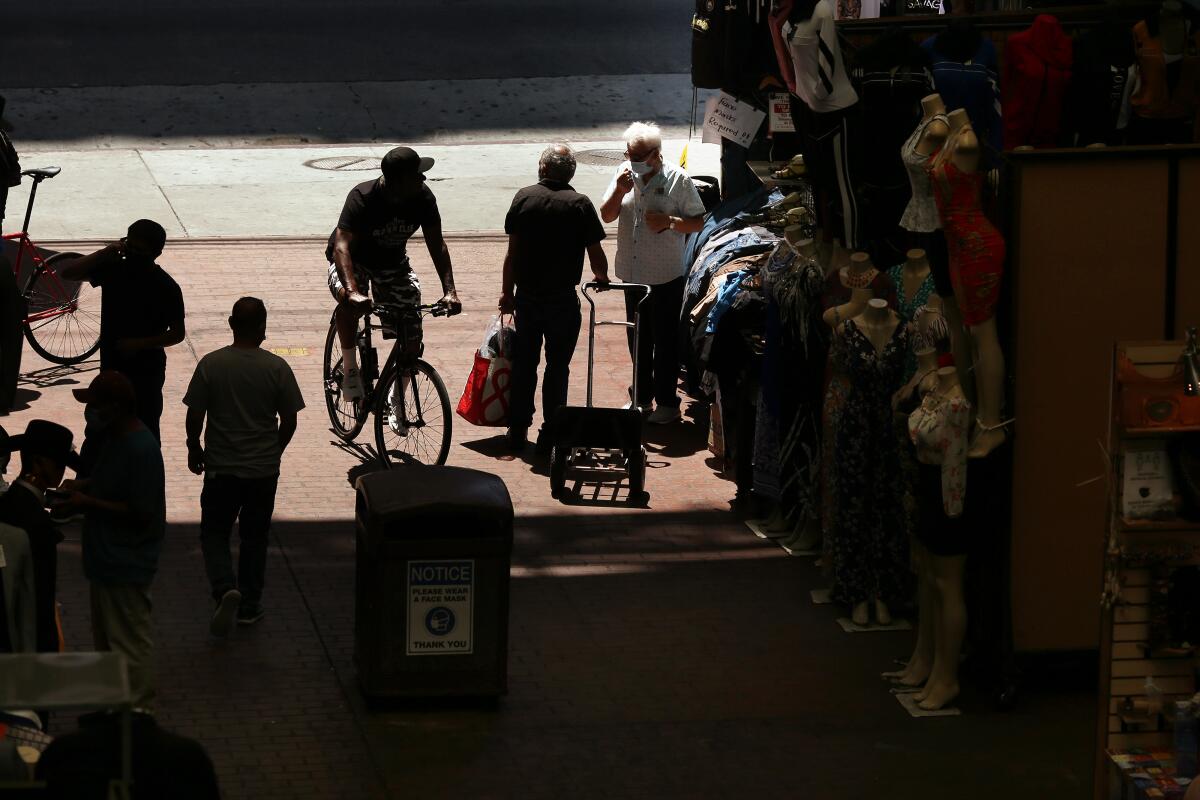 People walk along in Santee Alley on Monday, July 20, 2020 in Los Angeles, CA. Officials reported