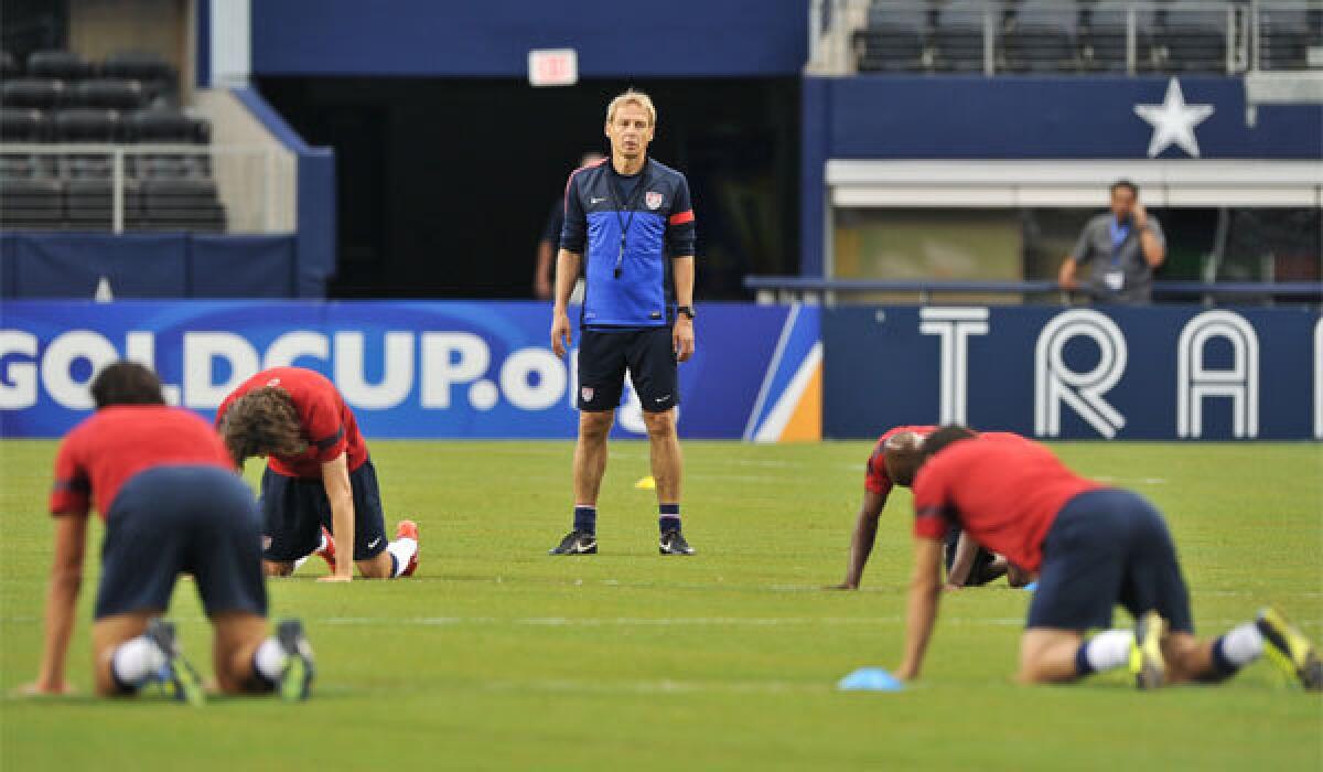 U.S. Coach Juergen Klinsmann watches his players stretch during a Gold Cup training session at Cowboys Stadium on Tuesday.