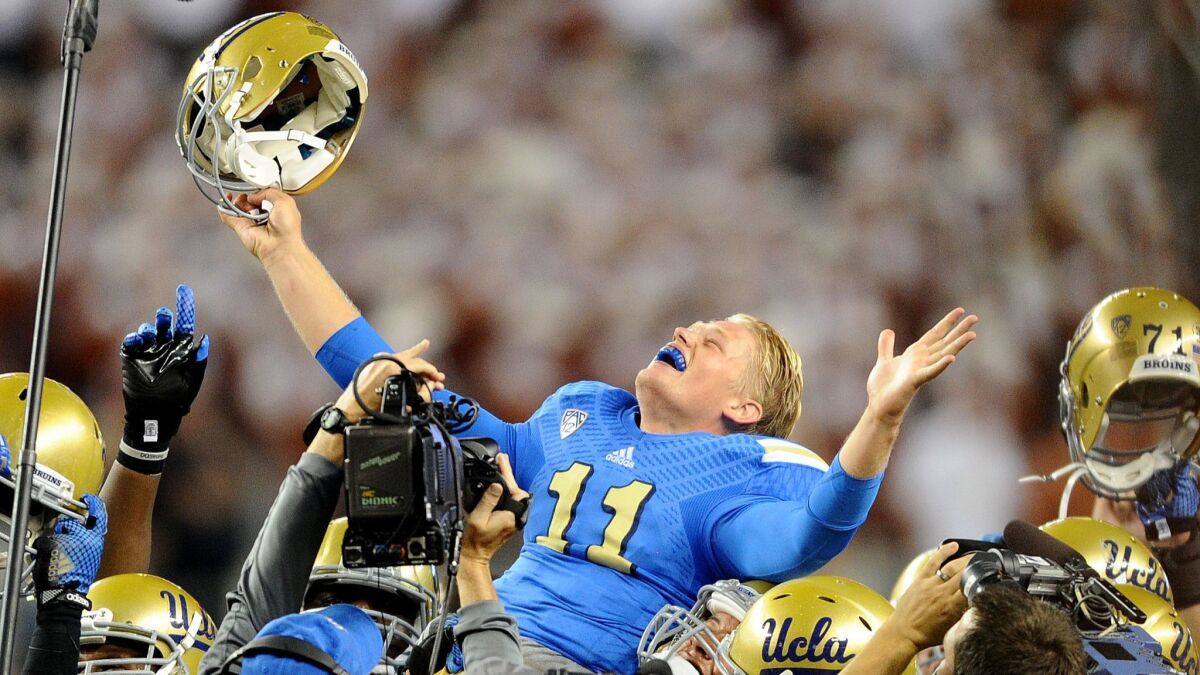 UCLA quarterback Jerry Neuheisel is lifted into the air by teamates after an improbable victory over Texas on Sept. 13, 2014.