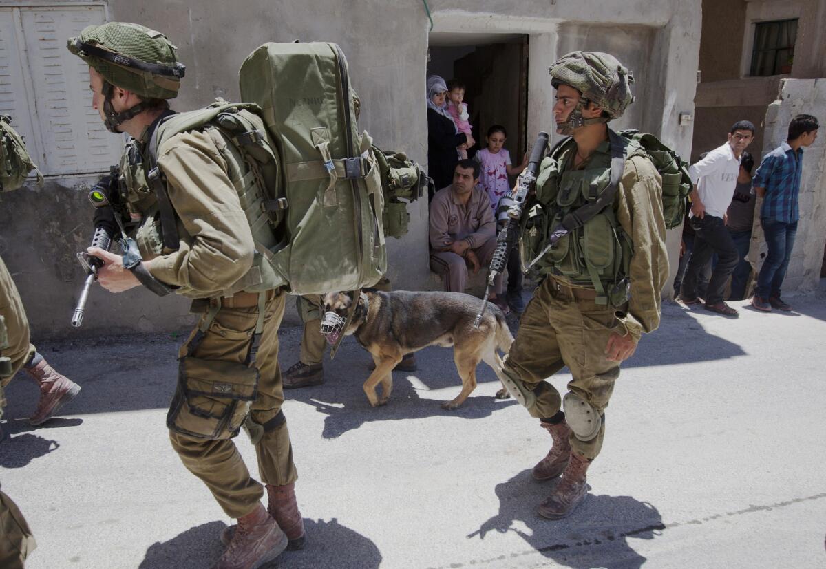 Israeli soldiers patrol during a military operation to search for three missing teenagers outside the West Bank city of Hebron on Sunday.