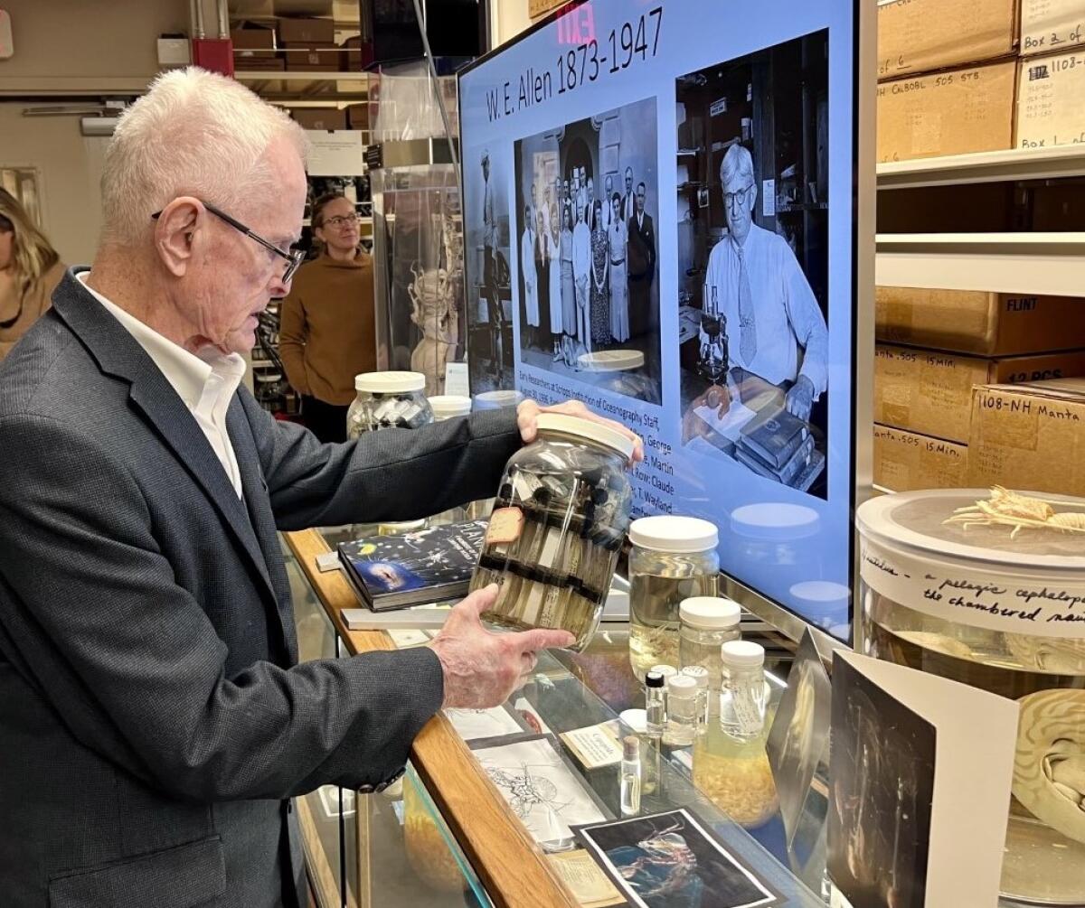 Henry Allen Brubaker looks at phytoplankton samples gathered 100 years ago by his grandfather W.E. Allen, pictured at right.