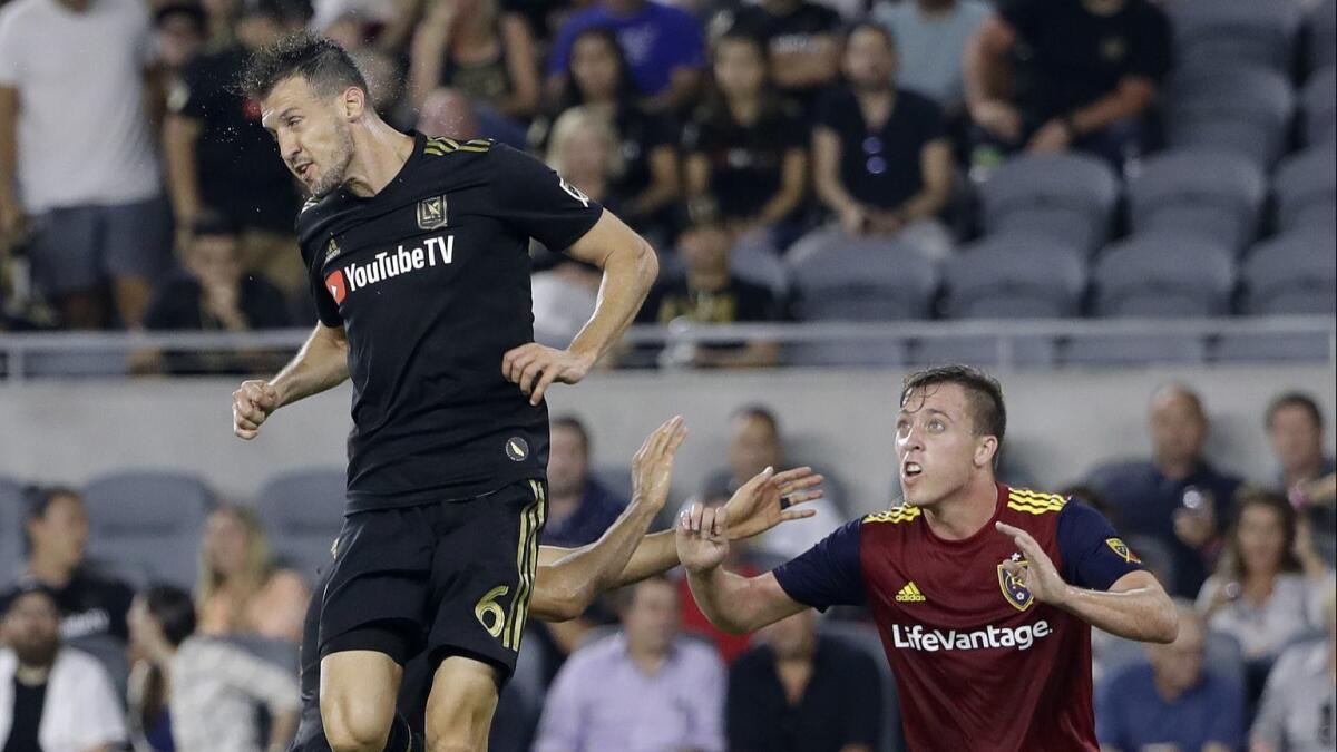 LAFC's Danilo Silva heads the ball next to Real Salt Lake's Corey Baird during a match.