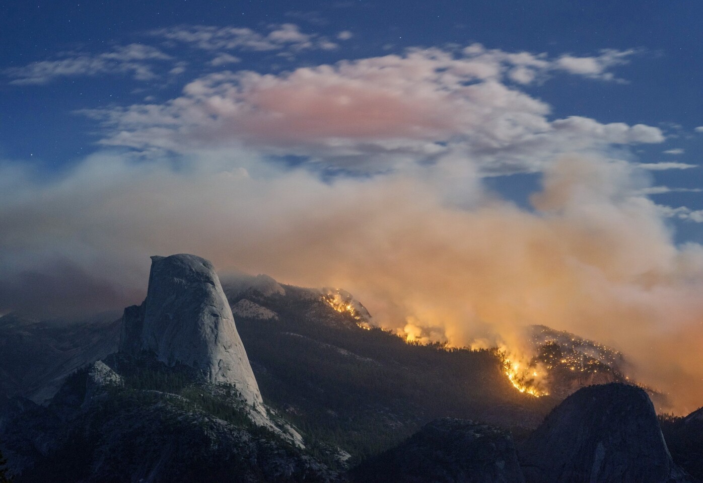 A wildfire burns next to Half Dome in Yosemite National Park.