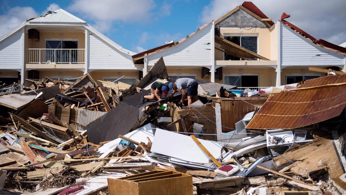 Two men look for belongings in the rubble of their restaurant on Sunday in Orient Bay on the French Carribean island of St. Martin.