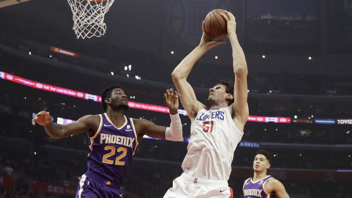 Clippers' Boban Marjanovic (51) grabs an offensive rebound over Phoenix Suns' Deandre Ayton (22) and puts it back in.