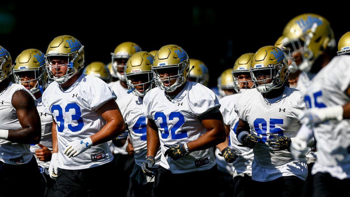UCLA linebacker Mique Juarez (32) and members of the defensive teams participate in warmups during the first day of fall camp at UCLA's Wasserman Football Center on Aug. 3.