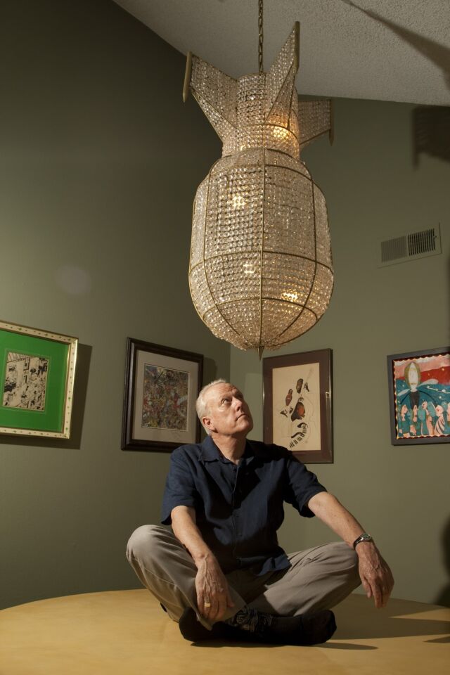 Bray sits beneath the chandelier sculpture, "Atom Bomb" by Hans van Bentem (2006), which hangs over Bray's dining table.