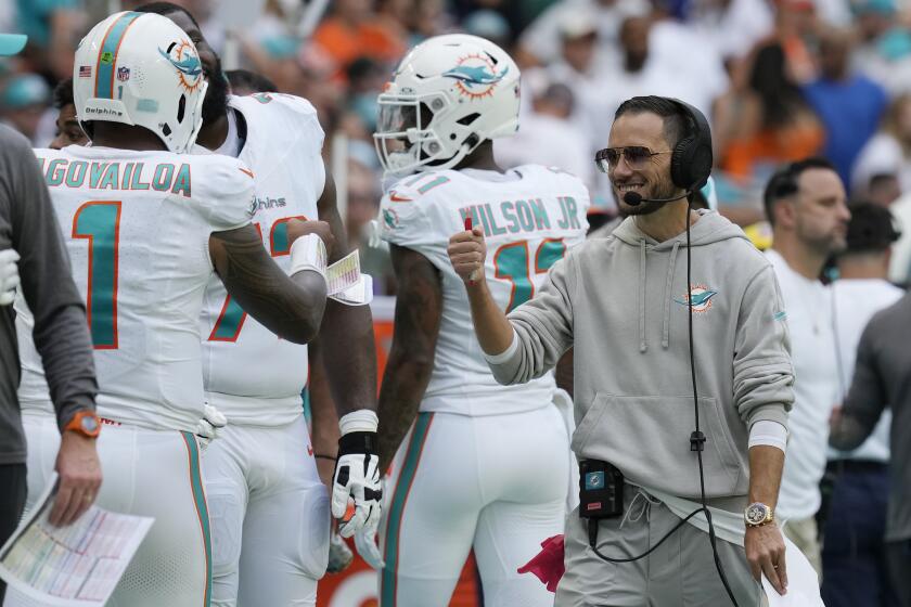 Miami Dolphins head coach Mike McDaniel fist bumps quarterback Tua Tagovailoa (1) as he leaves the game during the second half of an NFL football game against the Denver Broncos, Sunday, Sept. 24, 2023, in Miami Gardens, Fla. (AP Photo/Rebecca Blackwell)