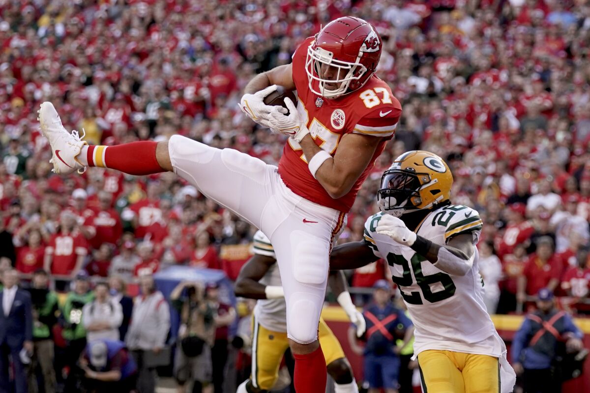 Kansas City Chiefs tight end Travis Kelce (87) catches a touchdown pass as Green Bay Packers safety Darnell Savage (26) defends during the first half of an NFL football game Sunday, Nov. 7, 2021, in Kansas City, Mo. (AP Photo/Charlie Riedel)