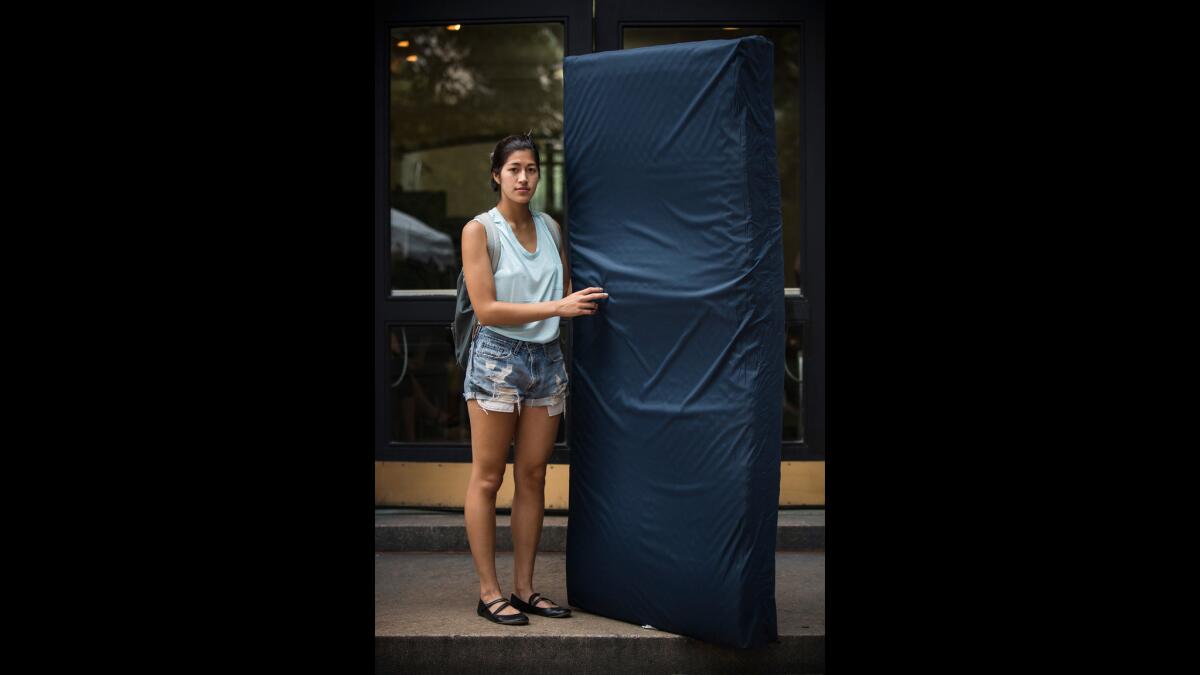 Emma Sulkowicz poses with the mattress she carried around Columbia as part of a yearlong art project in September 2014.