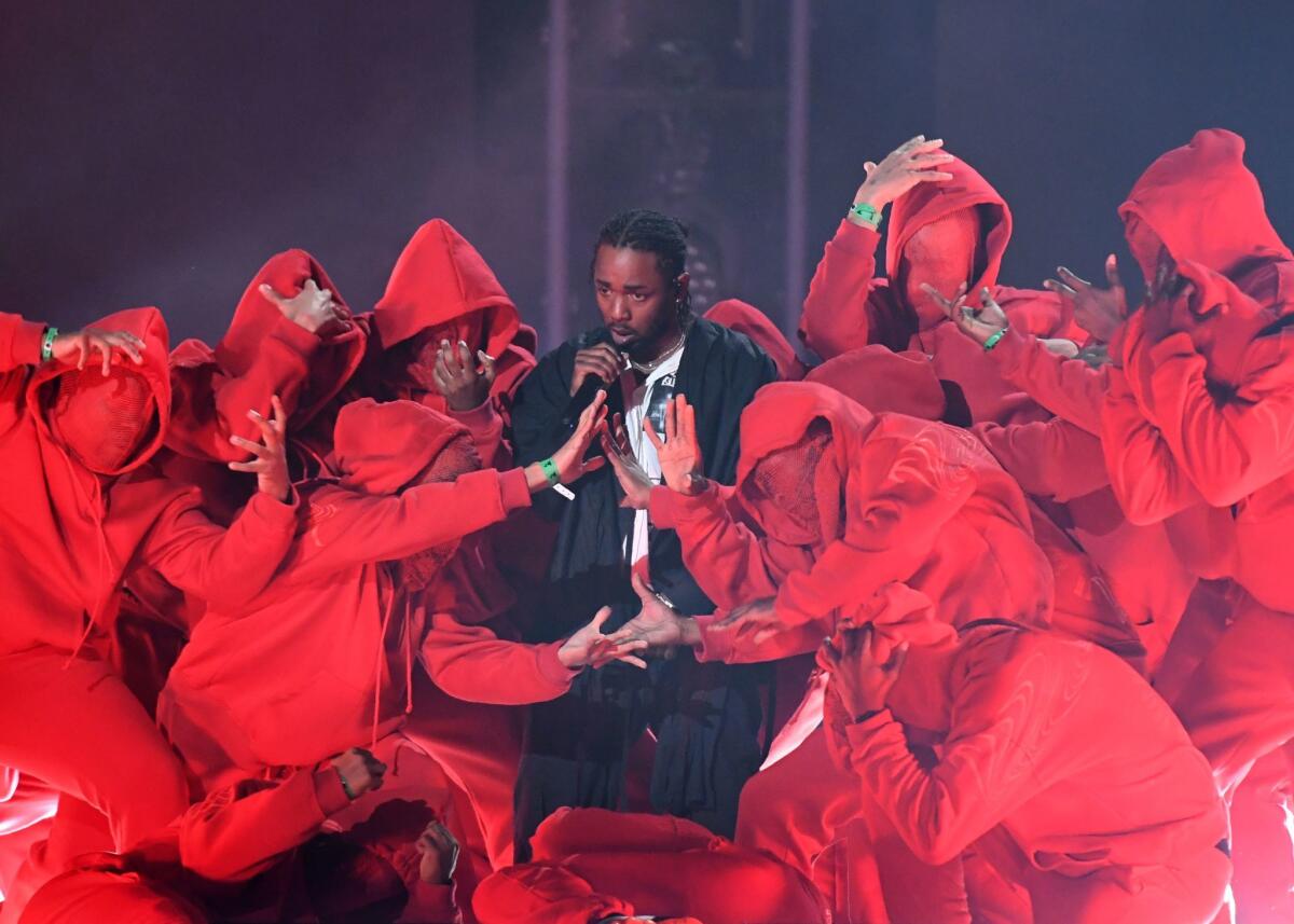Kendrick Lamar performs surrounded by hooded dancers at the 60th Grammy Awards.