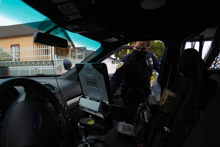 National City police Officer Ruben Lopez looks at the computer system in his vehicle.