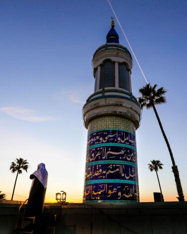 A blue and white turret at the King Fahad Mosque at sunset.