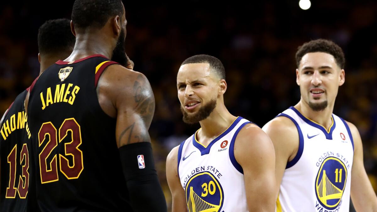 Warriors guard Stephen Curry (30) exchanges words with LeBron James during overtime of Game 1 on Sunday.