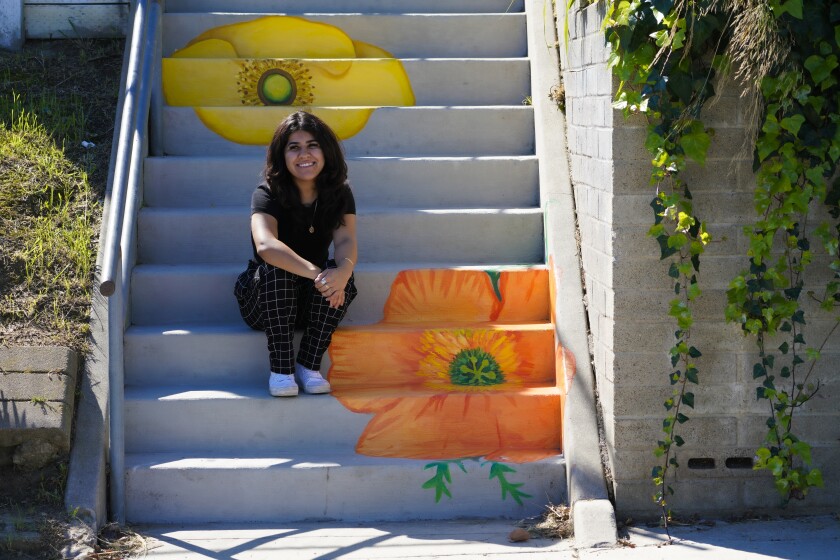Isabel García se sentó junto a una de sus pinturas a lo largo del camino de las "escaleras secretas"