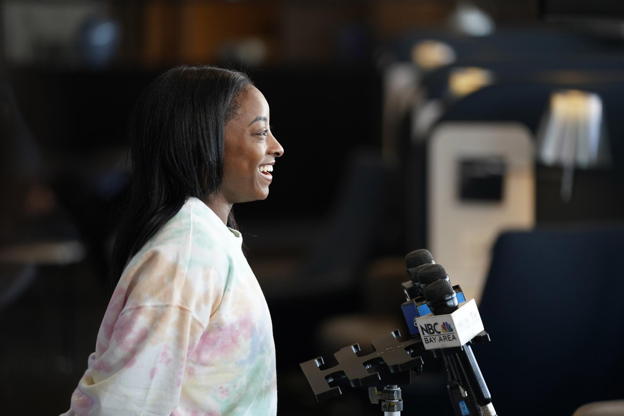 Simone Biles smiles during interviews at a United Airlines send-off event