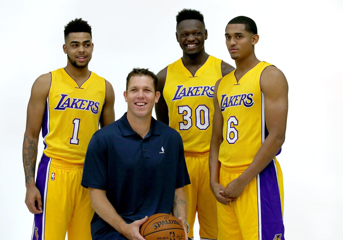 Lakers D'Angelo Russell (1), Julius Randle (30) and Jordan Clarkson (6) pose for photos with Coach Luke Walton during the team's media day.