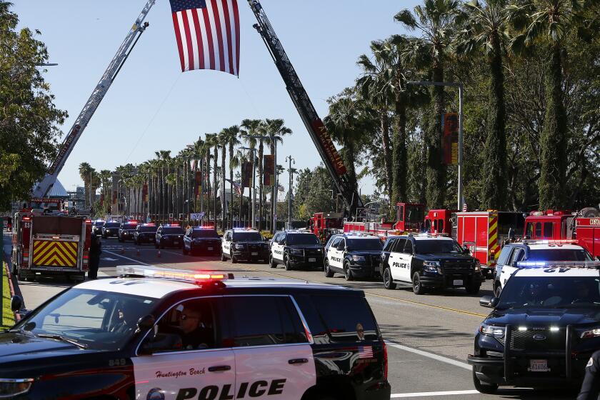 Members of the Huntington Beach police department arrive as part of the procession for Huntington Beach Police Officer Nicholas VellaOs memorial on Tuesday morning at the Honda Center in Anaheim.